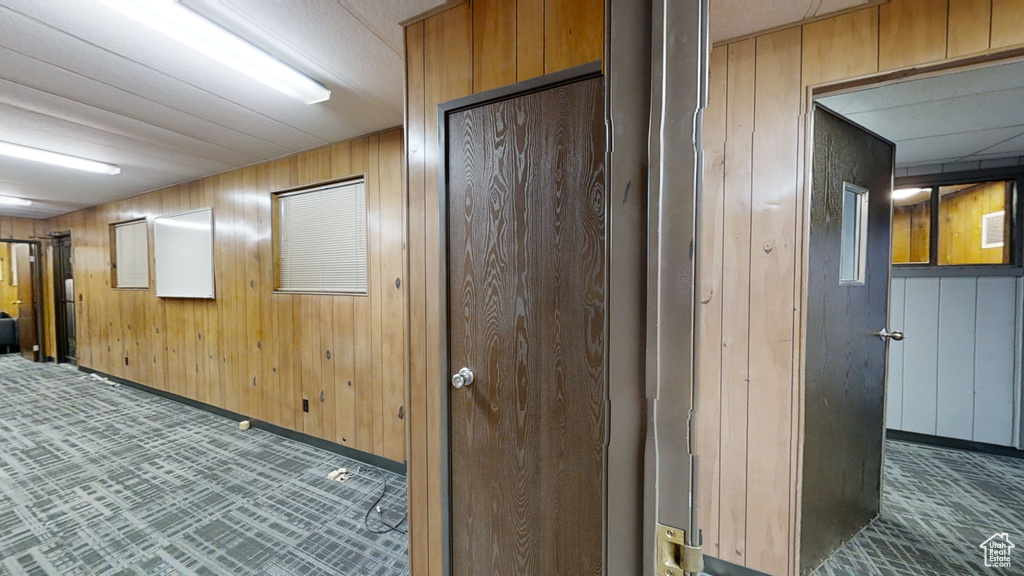 Hall featuring wood walls and baseboards