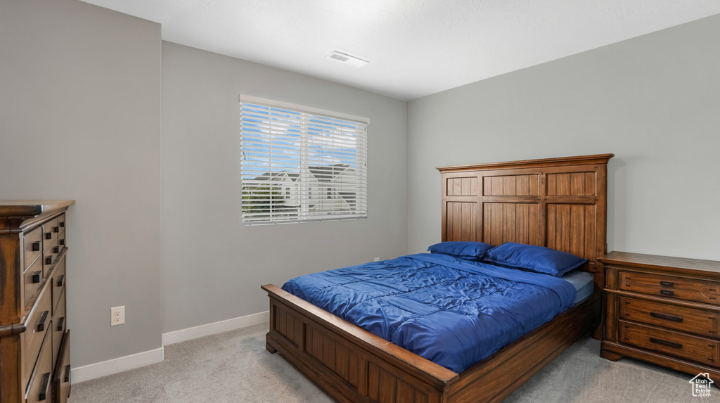 Bedroom with light colored carpet and baseboards