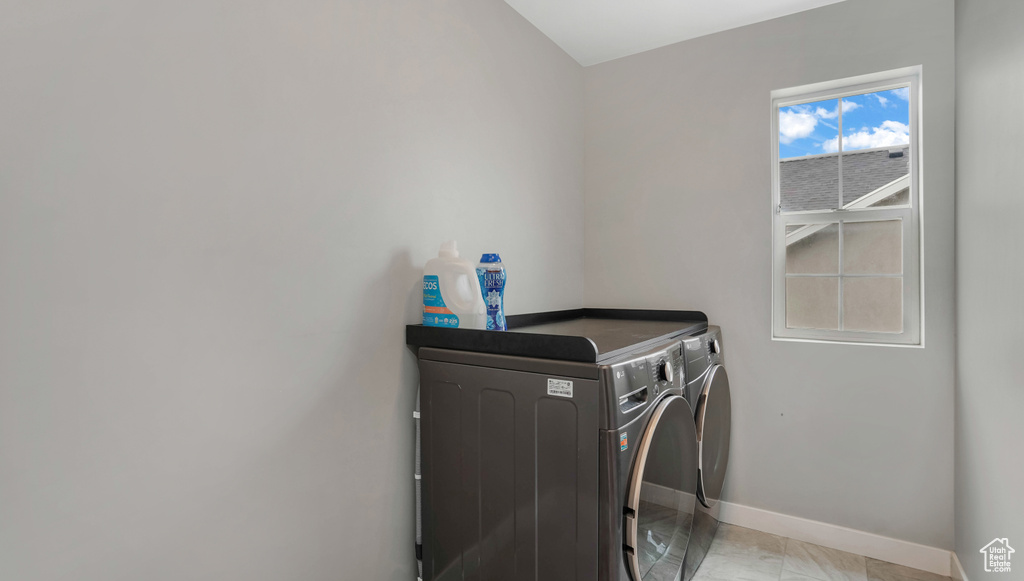 Laundry area with washing machine and dryer and baseboards
