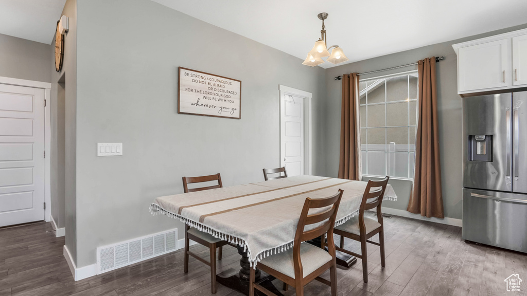 Dining room featuring a chandelier, wood finished floors, and baseboards