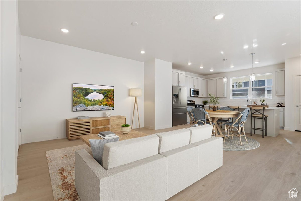 Living area with light wood finished floors and recessed lighting