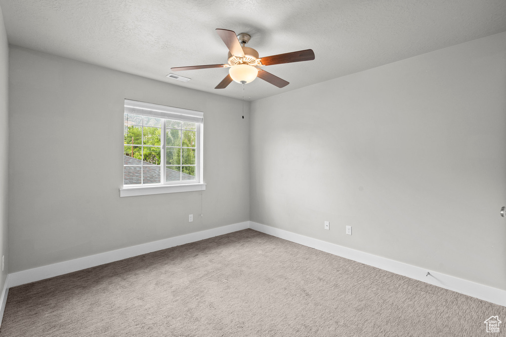 Unfurnished room featuring ceiling fan, baseboards, carpet flooring, and a textured ceiling
