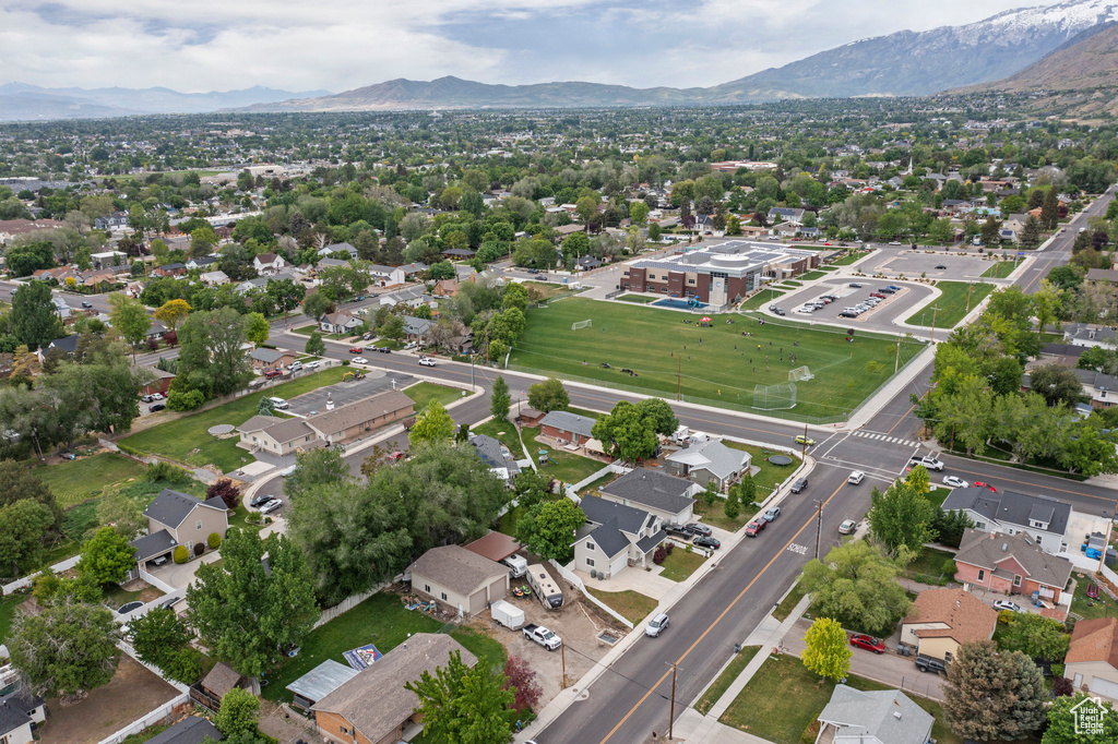 Aerial view of property and surrounding area with a mountain backdrop and nearby suburban area