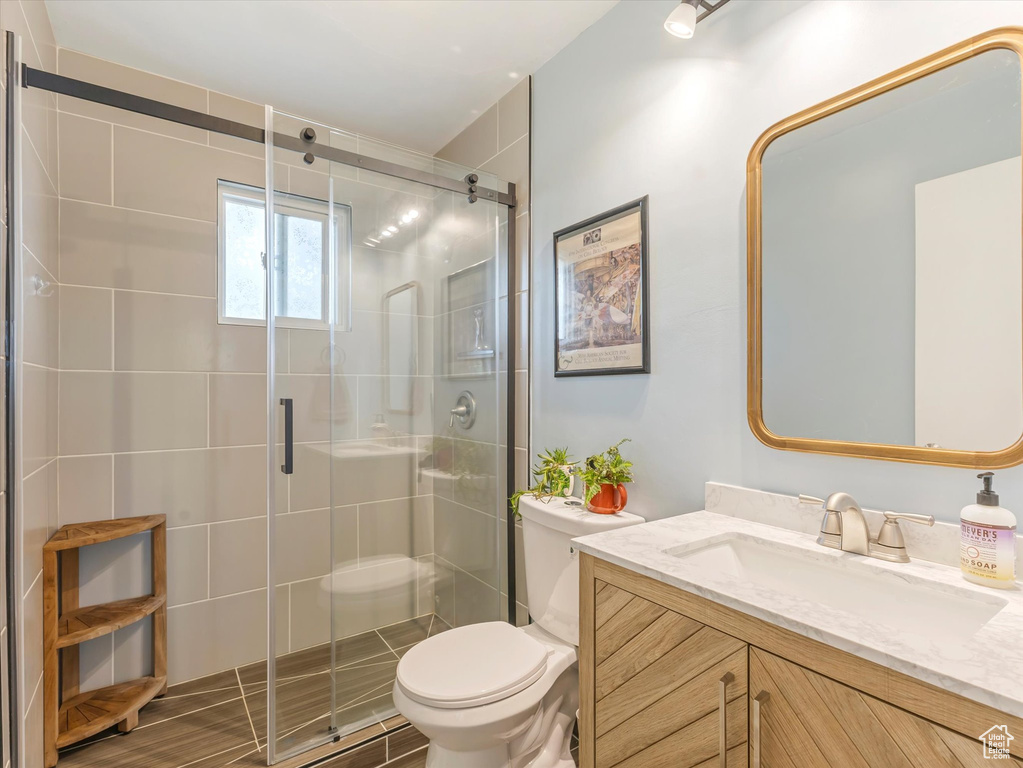 Full bathroom featuring toilet, a shower stall, and vanity