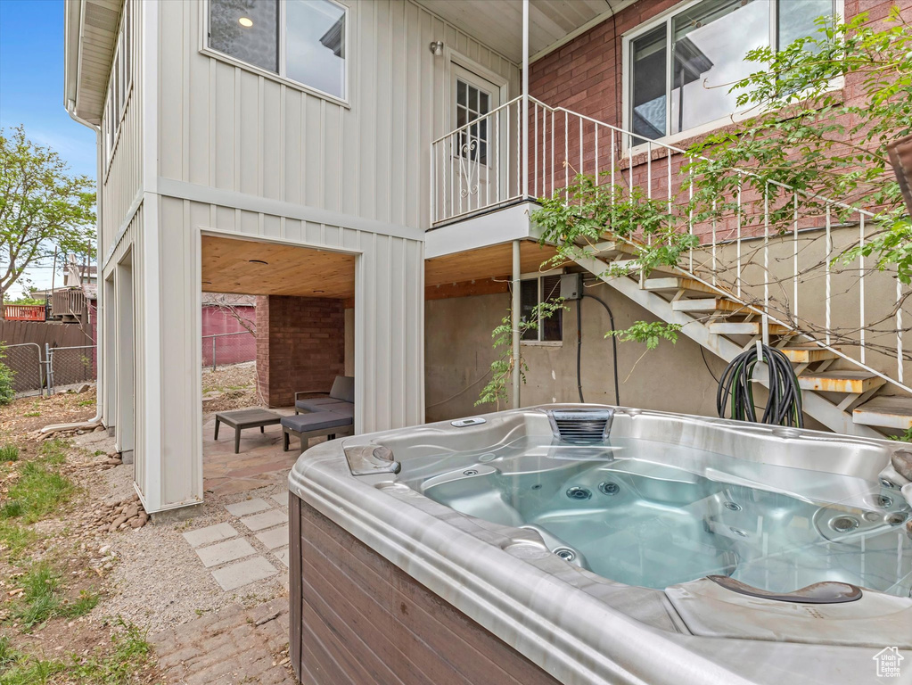 View of swimming pool featuring a hot tub and fence
