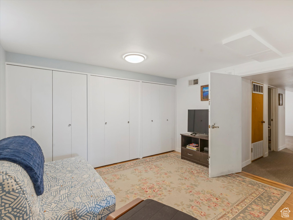 Bedroom featuring multiple closets, wood finished floors, and baseboards