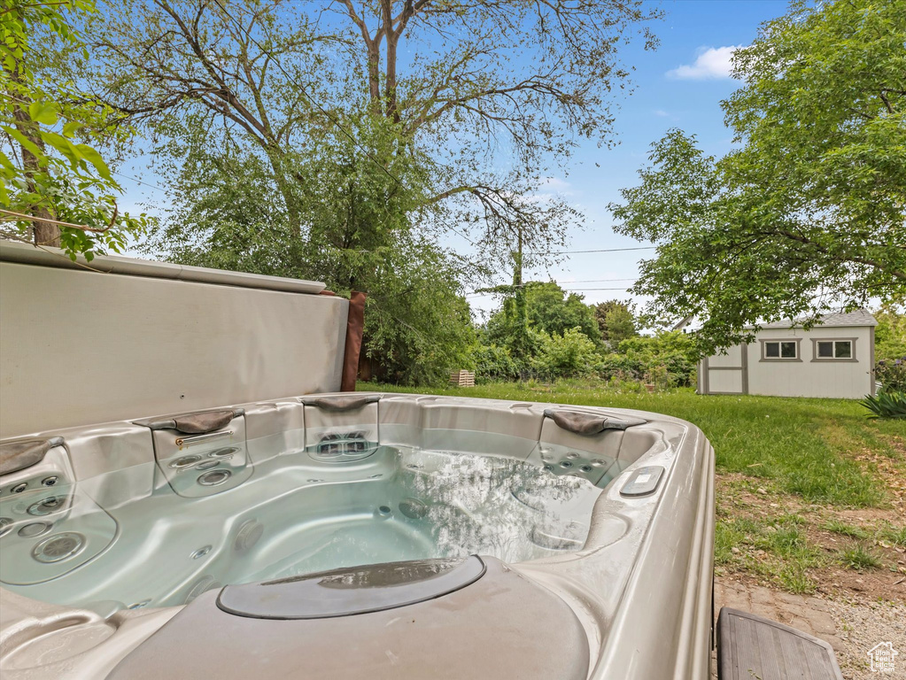 View of pool featuring an outbuilding and a hot tub