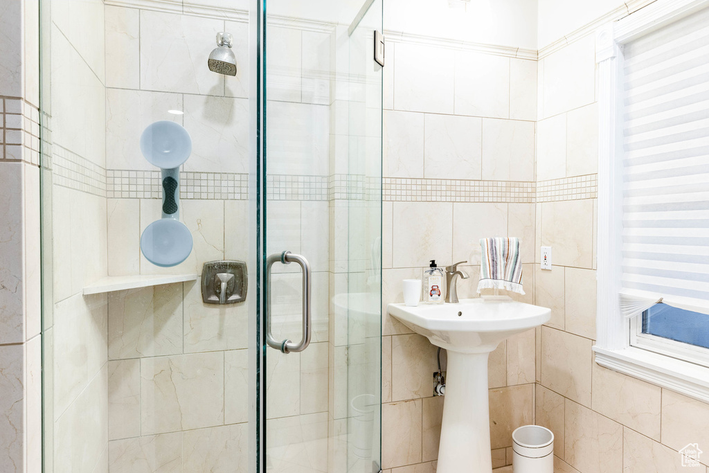 Full bath featuring tile walls and a shower stall