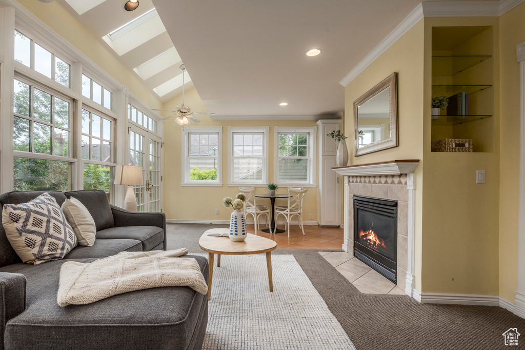 Living room featuring a fireplace, baseboards, ornamental molding, recessed lighting, and light tile patterned flooring