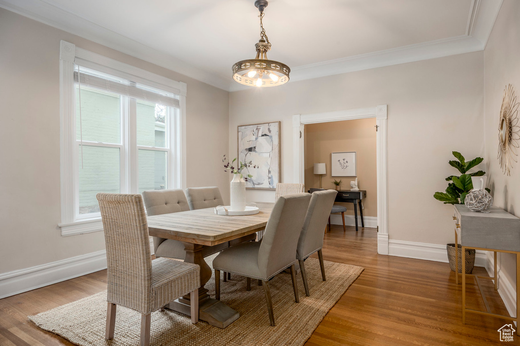 Dining room with light wood-type flooring, baseboards, and ornamental molding
