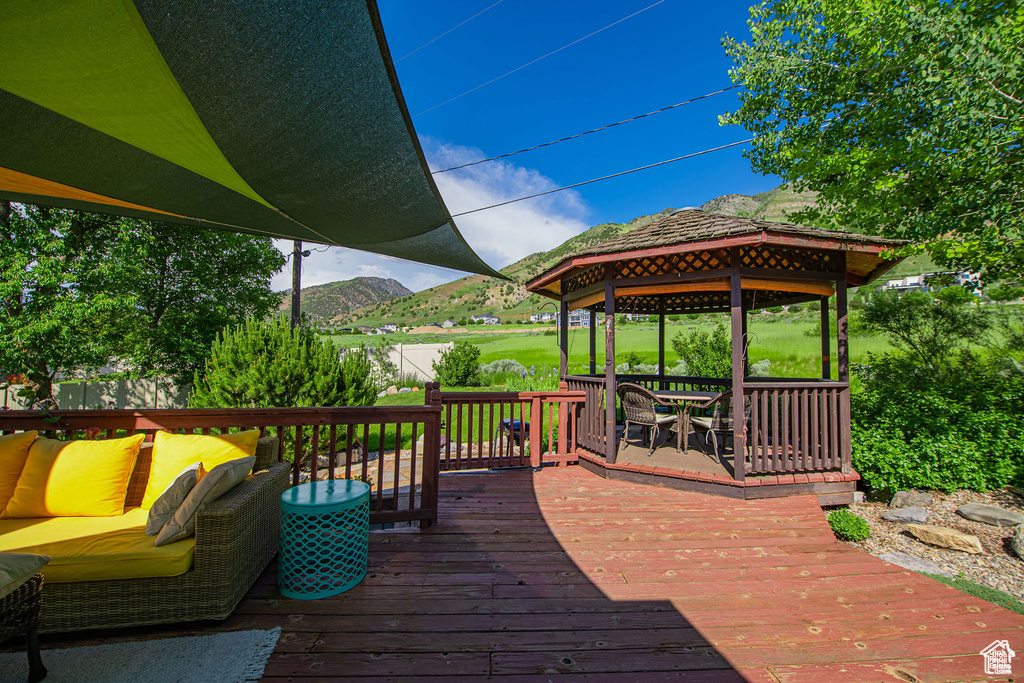 Wooden terrace featuring a gazebo and a mountain view