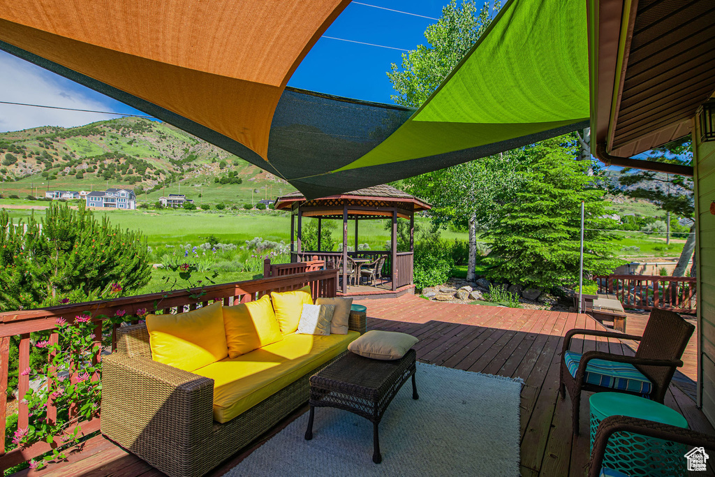 Deck with outdoor lounge area, a mountain view, and a gazebo