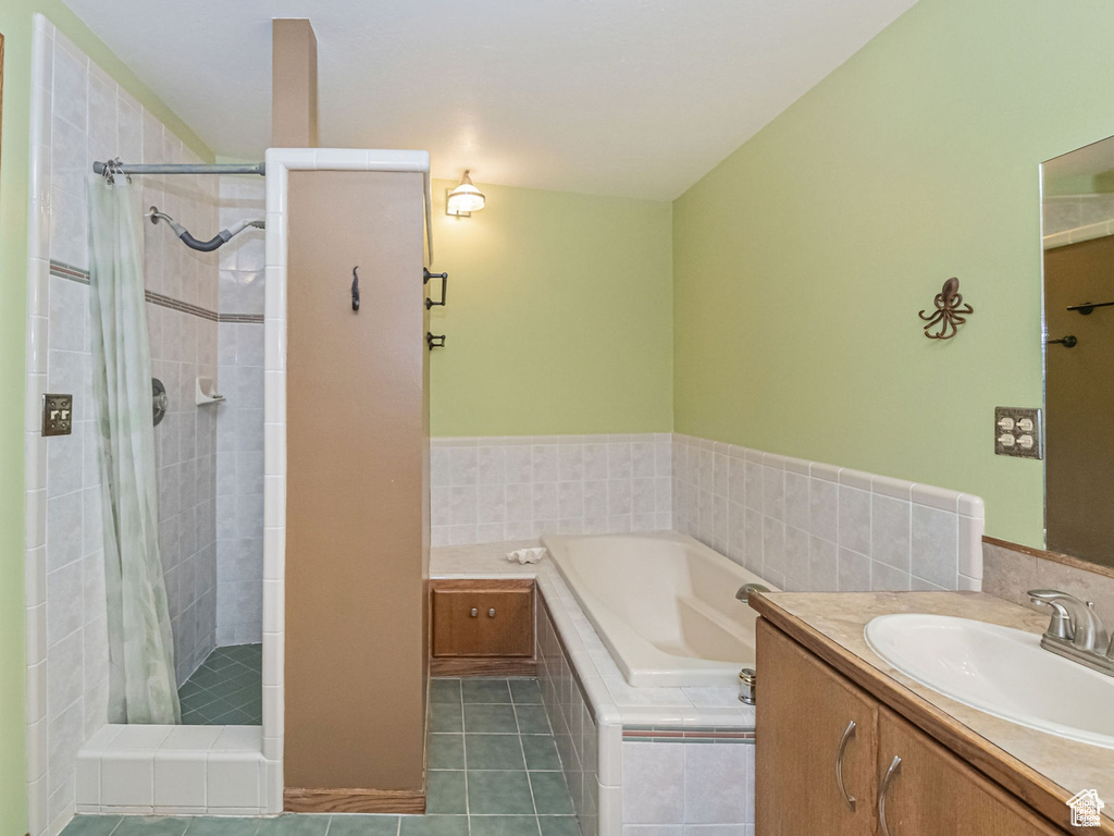 Bathroom with a stall shower, tile patterned flooring, vanity, and a garden tub