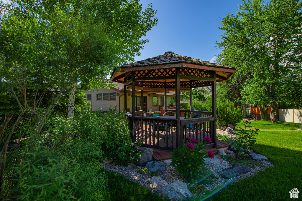 View of green lawn featuring a gazebo and a deck