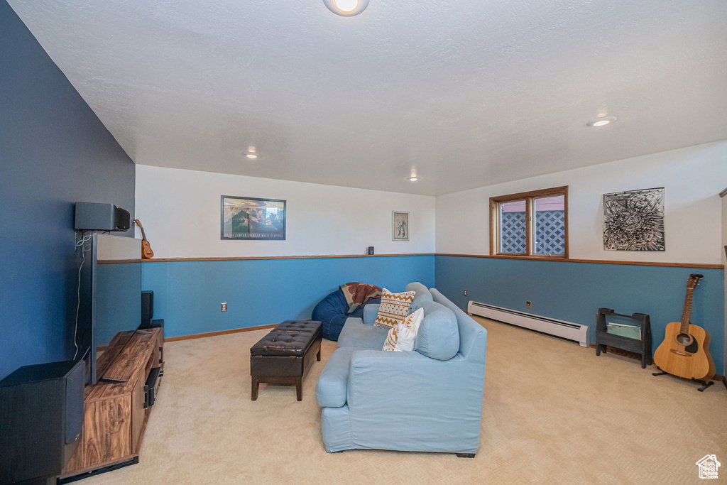 Living area with a baseboard radiator, carpet floors, and recessed lighting