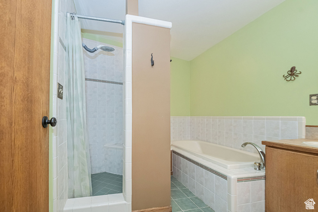 Bathroom featuring a shower stall, tile patterned floors, a bath, and vanity