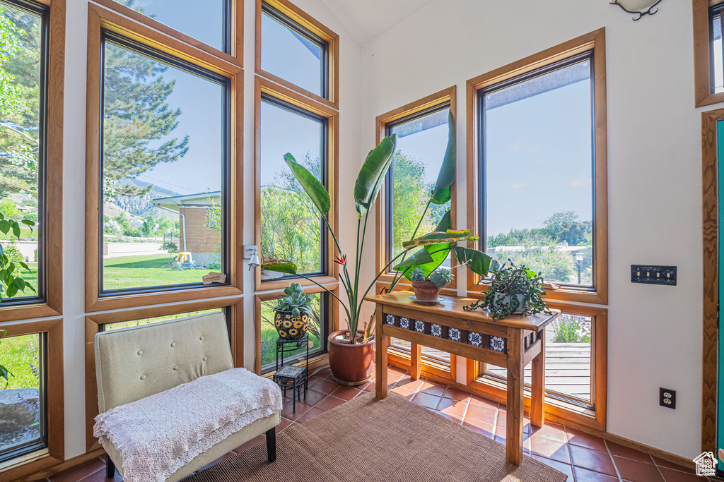 Sunroom / solarium featuring tile patterned flooring and lofted ceiling