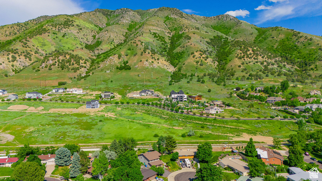 Aerial view of property and surrounding area featuring a mountain backdrop