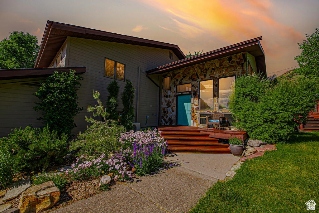 Mid-century home featuring stone siding and a front yard