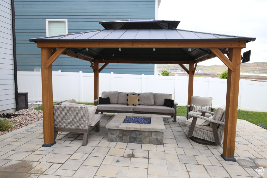 View of patio / terrace featuring a gazebo, an outdoor living space with a fire pit, and a fenced backyard