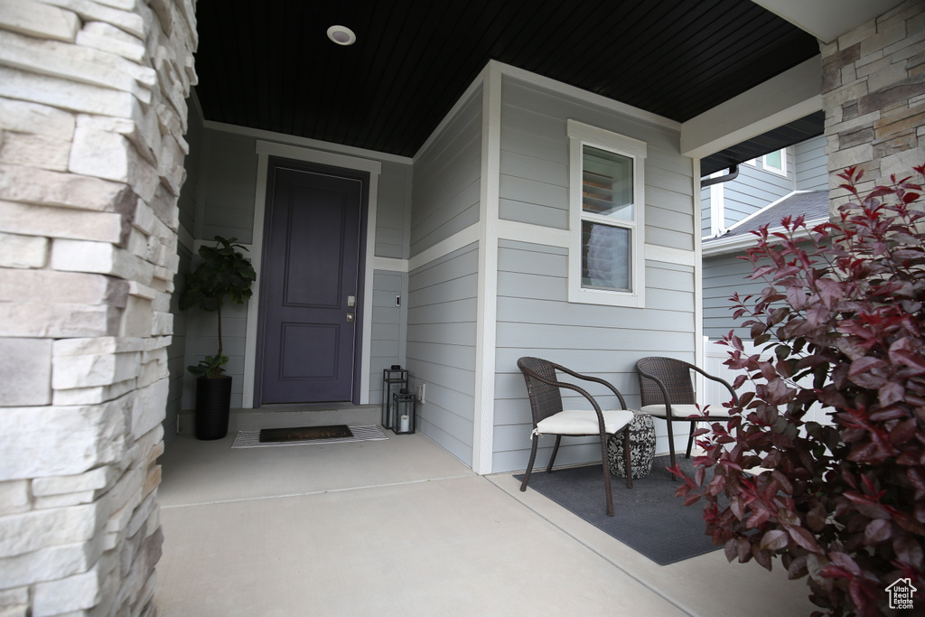 Doorway to property with stone siding and a porch