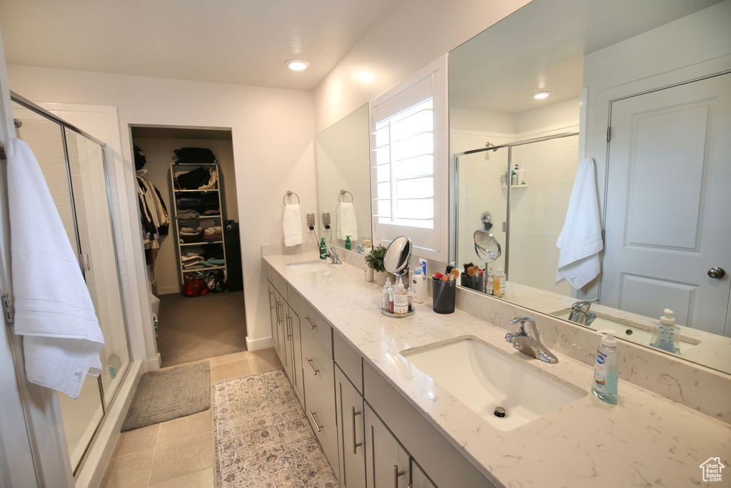 Full bathroom featuring a shower stall, double vanity, tile patterned flooring, and recessed lighting