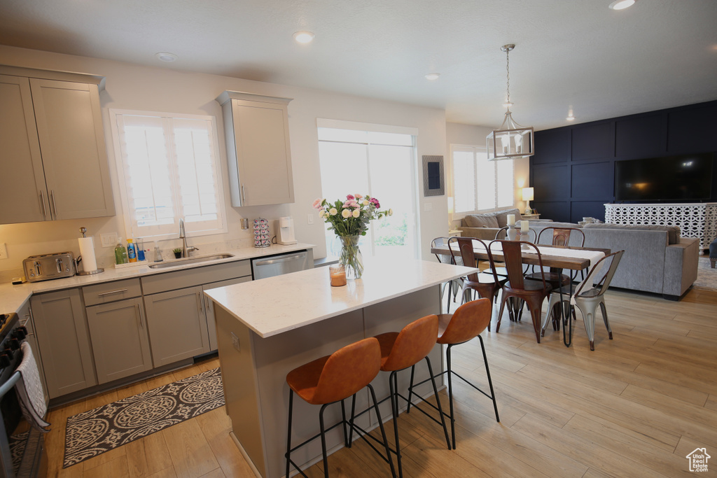 Kitchen with a sink, light countertops, open floor plan, and recessed lighting