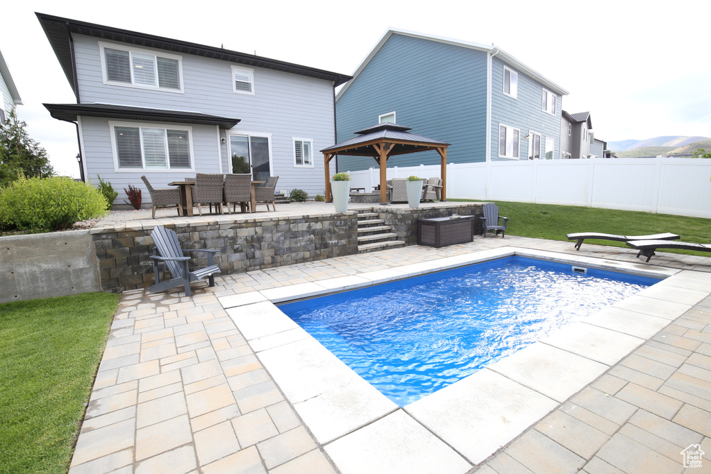View of pool with a gazebo, a patio, and outdoor dining space