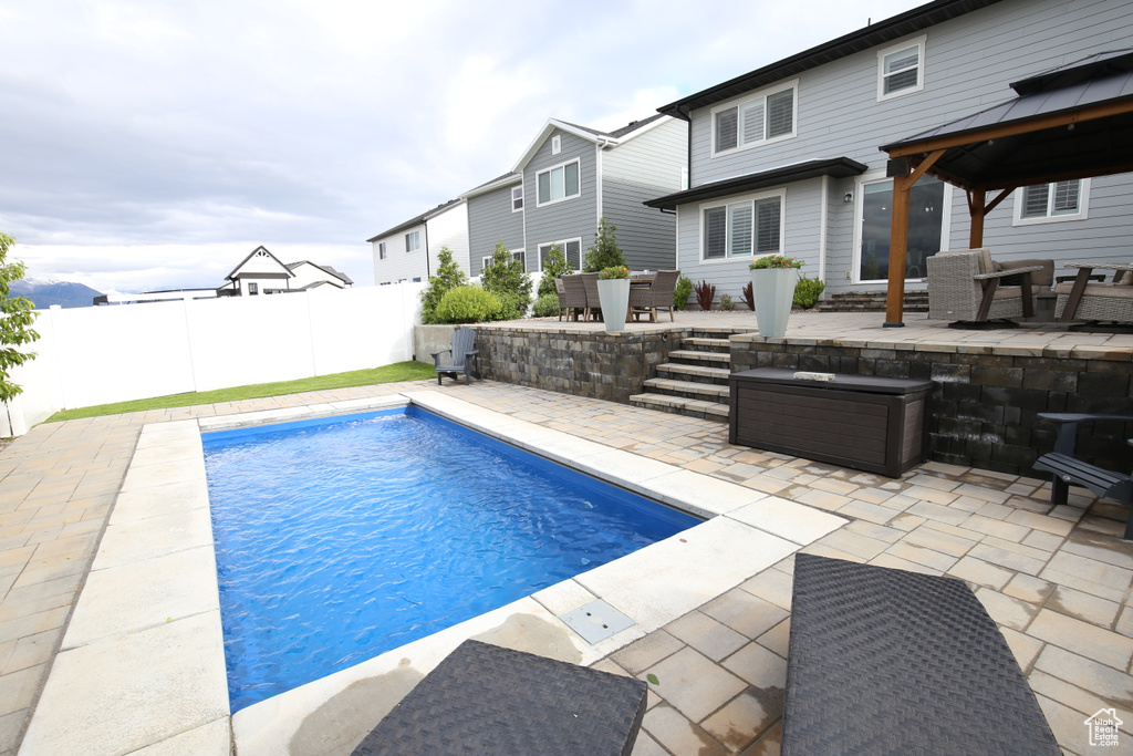 View of swimming pool featuring a gazebo, a patio, outdoor dining space, and fence