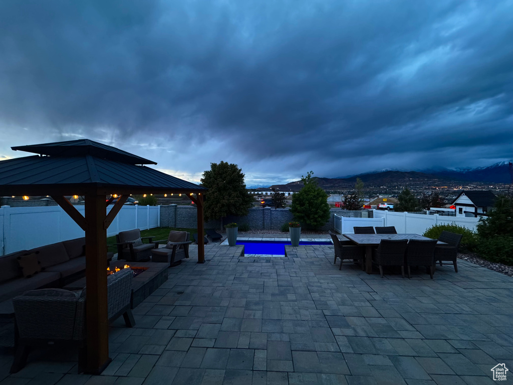 View of patio / terrace featuring a gazebo, an outdoor living space with a fire pit, a fenced backyard, and outdoor dining area