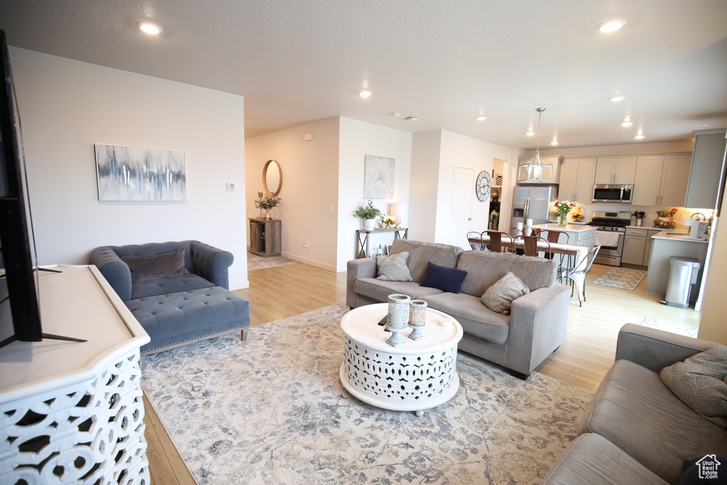 Living room with recessed lighting, light wood finished floors, and baseboards