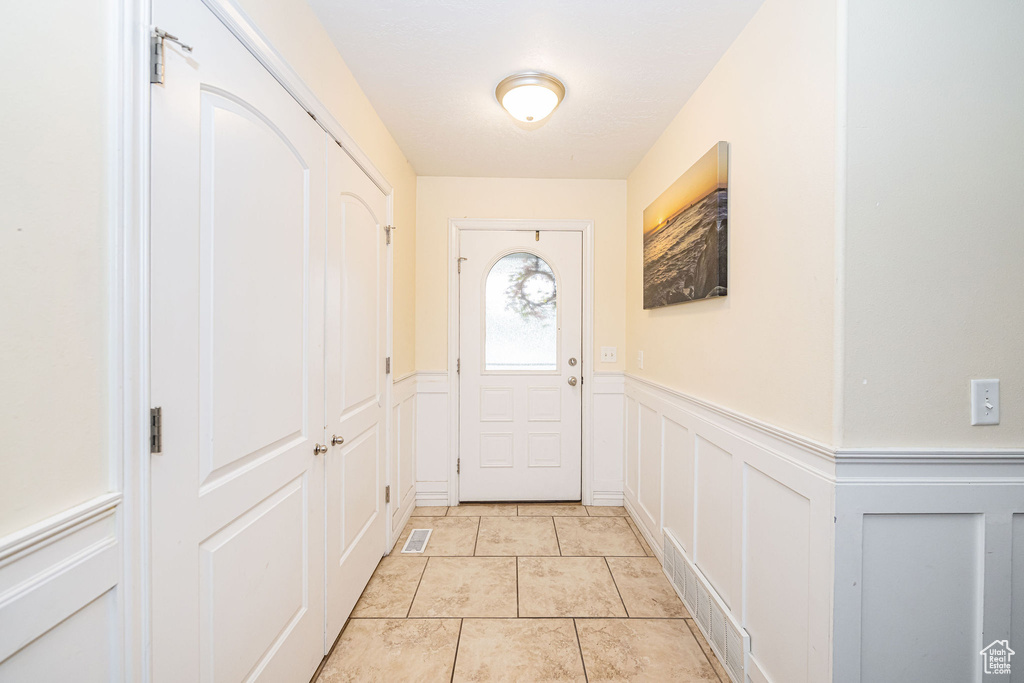 Entryway featuring a wainscoted wall and a decorative wall