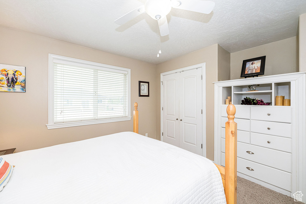 Bedroom with a closet, carpet floors, and ceiling fan
