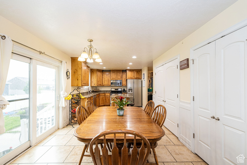 Dining area with light tile patterned floors, plenty of natural light, a chandelier, and recessed lighting