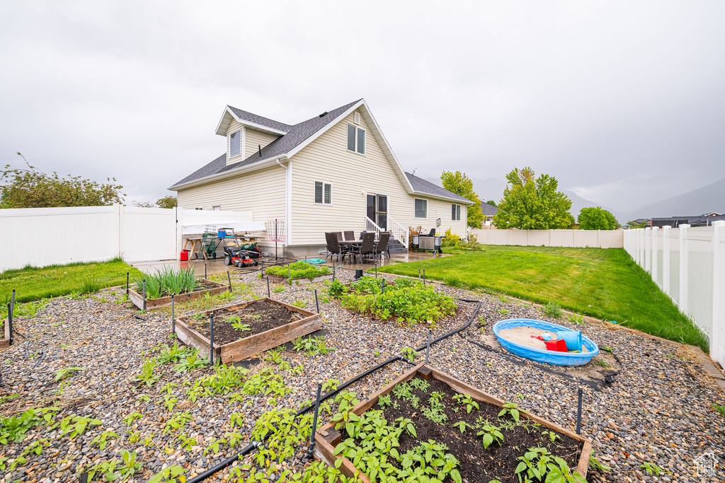 Rear view of property featuring a garden