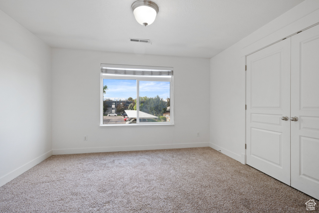 Unfurnished bedroom with carpet, baseboards, and a closet