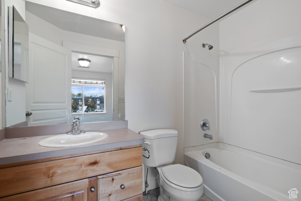 Bathroom with toilet, shower / tub combination, and vanity