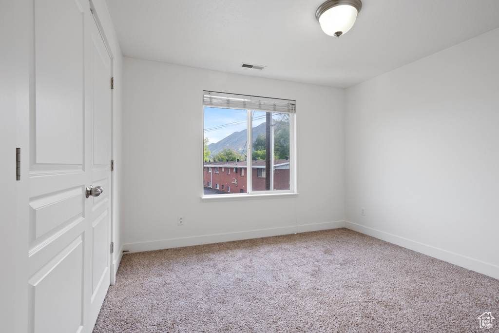 Carpeted spare room with baseboards