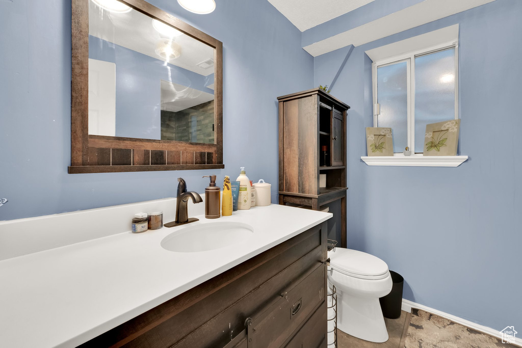 Bathroom with vanity, toilet, and baseboards