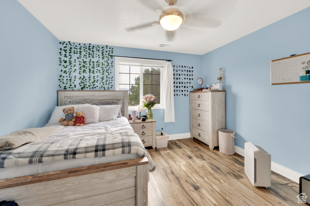 Bedroom featuring wood finished floors, baseboards, and a ceiling fan