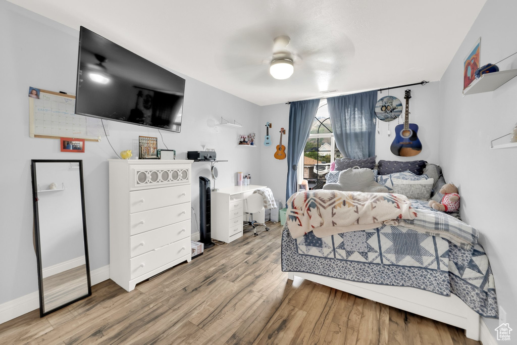 Bedroom featuring wood finished floors, baseboards, and a ceiling fan