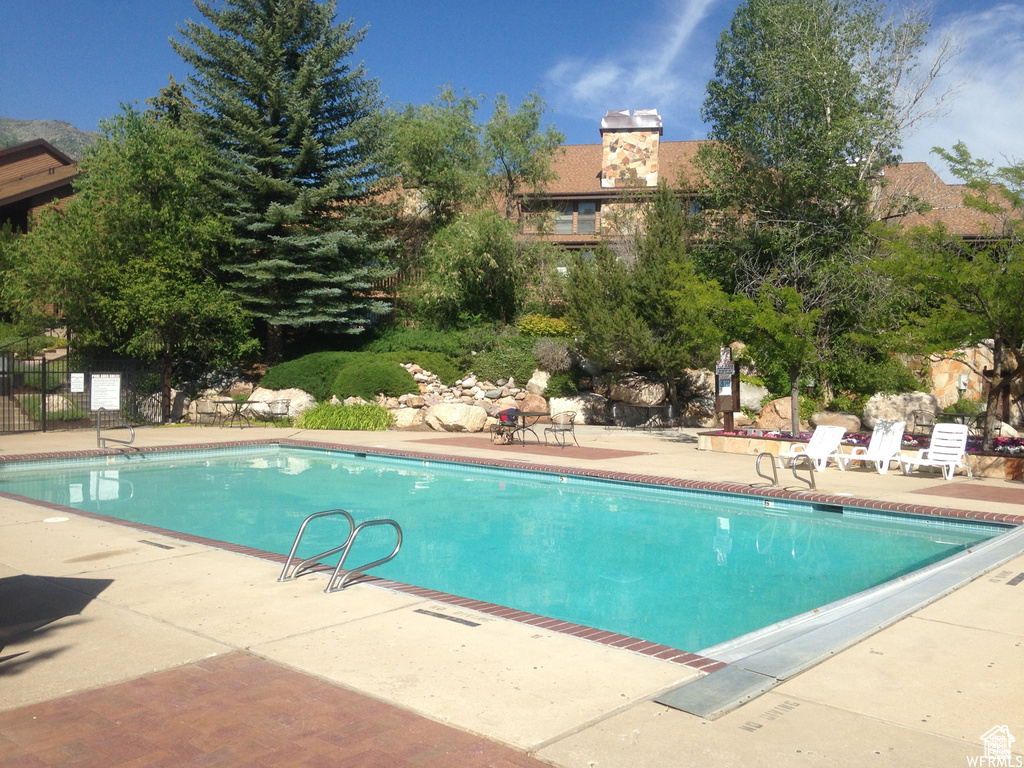 View of pool featuring a patio area and fence
