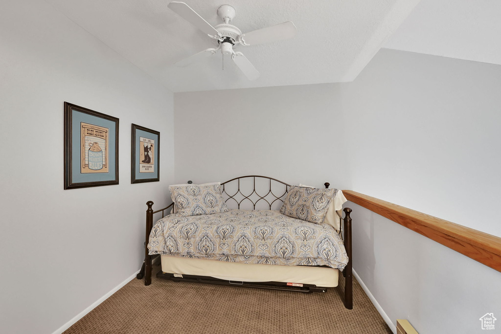 Carpeted bedroom featuring baseboards and a ceiling fan