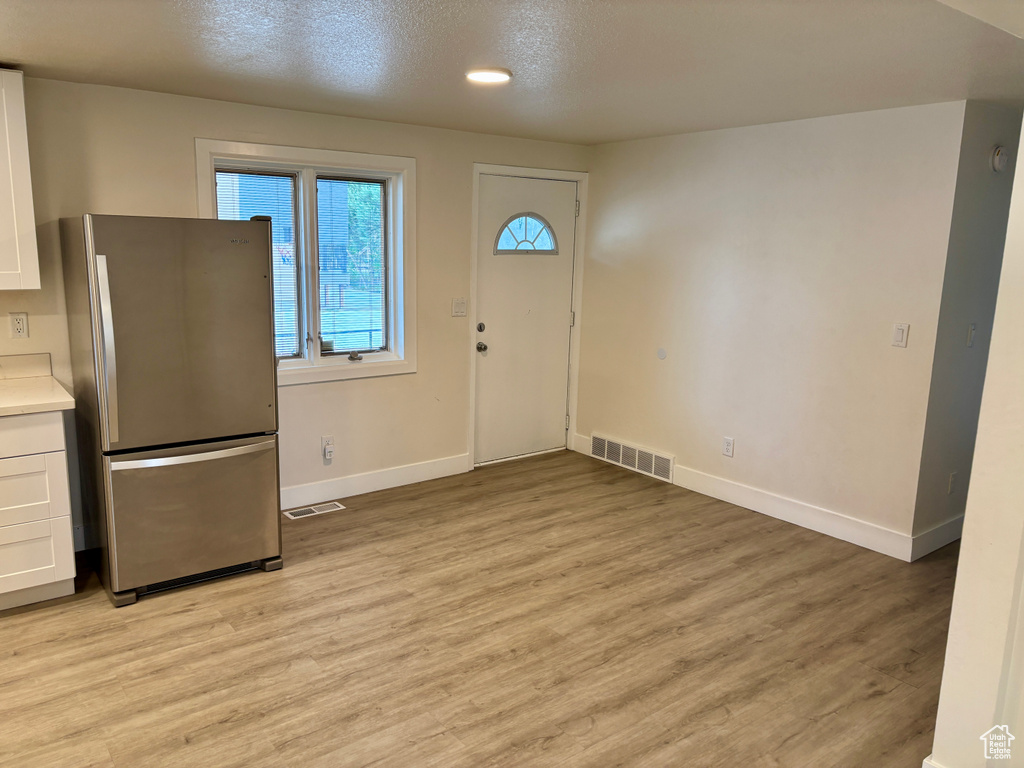 Foyer entrance with baseboards and light wood-type flooring