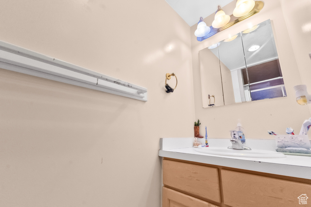 Bathroom with vanity and lofted ceiling