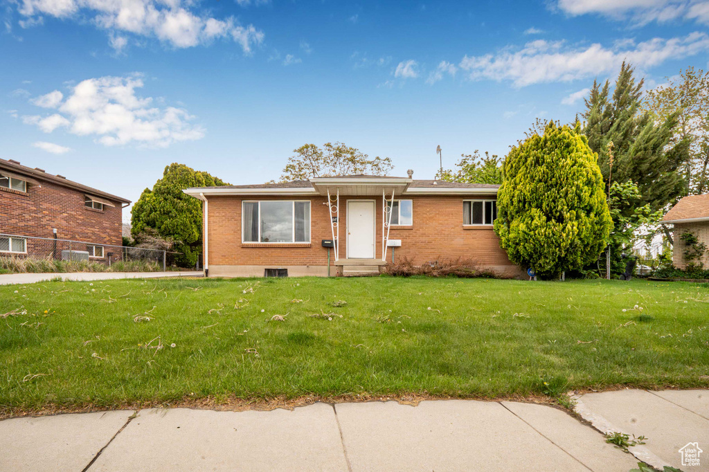 View of front of home with brick siding, a front lawn, and entry steps
