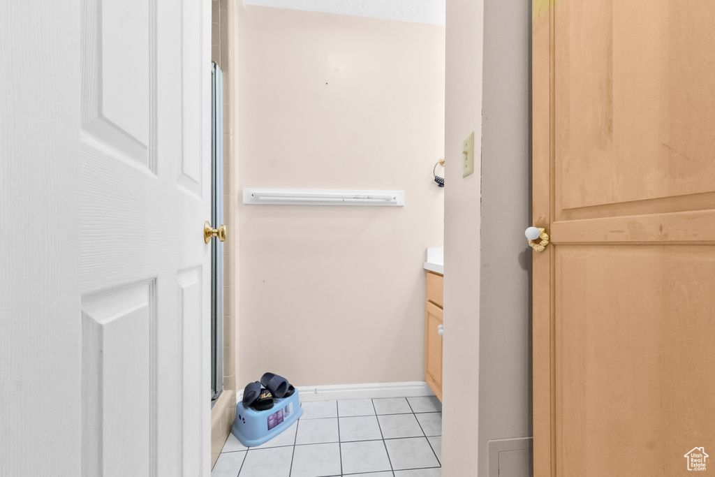 Full bathroom featuring baseboards, a shower, tile patterned flooring, and vanity
