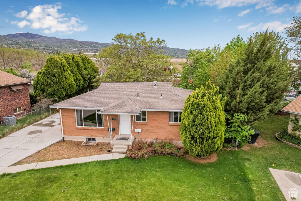 Single story home featuring fence, central AC unit, a mountain view, and brick siding