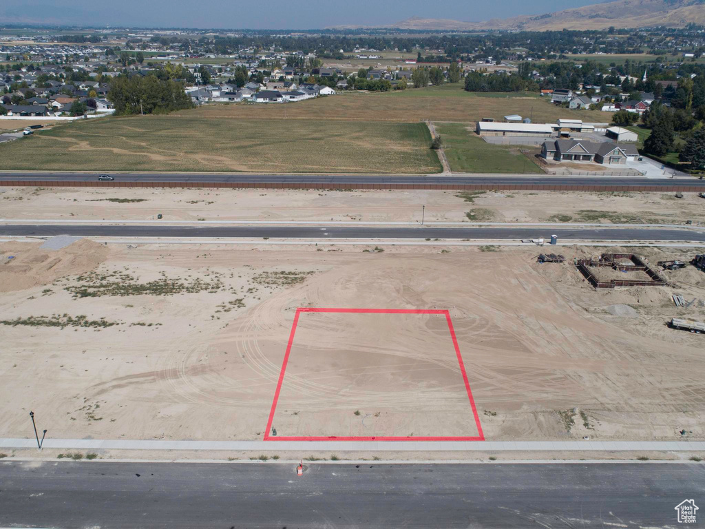 Aerial view of property and surrounding area featuring property parcel outlined and a mountainous background