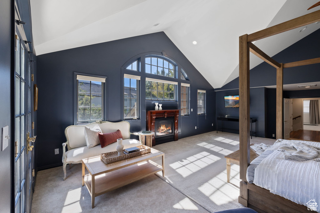 Carpeted bedroom featuring a glass covered fireplace, high vaulted ceiling, and recessed lighting